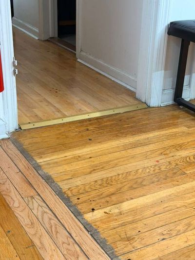 Oak floor transition with a brass saddle strip