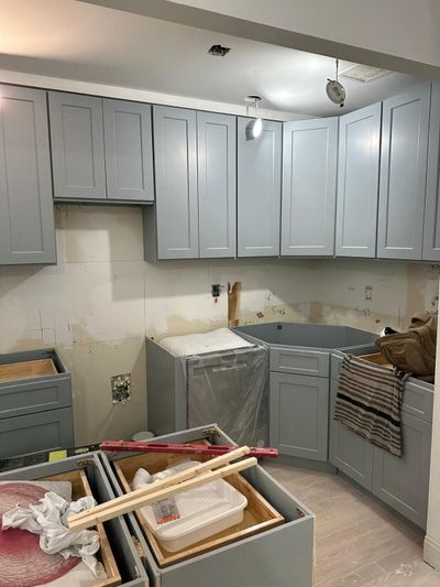 Light gray cabinets, wrapped dishwasher, and level during installation