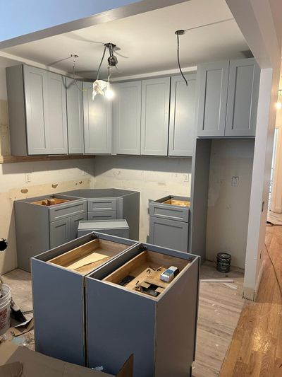 Gray Shaker-style kitchen cabinets during installation
